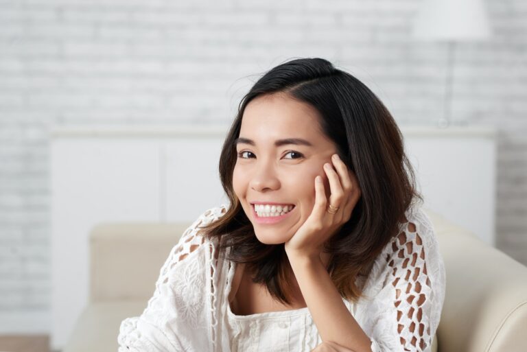 A woman smiling warmly, relaxed at home