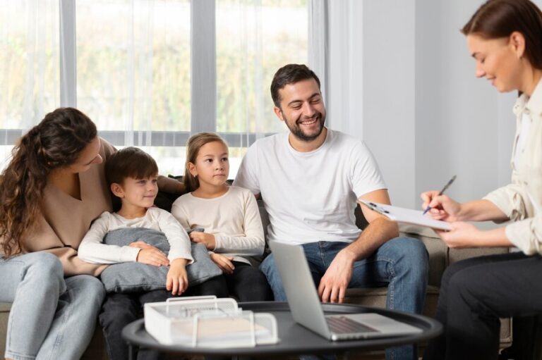 A family sitting together on a sofa talking with a therapist who is taking notes